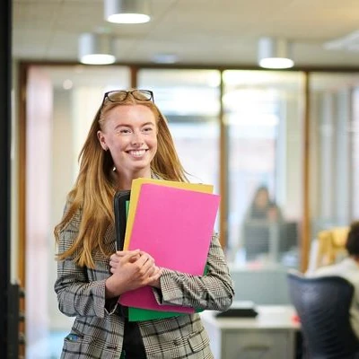 Woman smiling holding folders