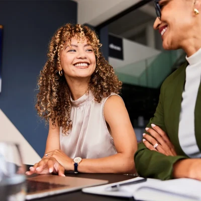 Woman sitting at a desk smiling at another woman