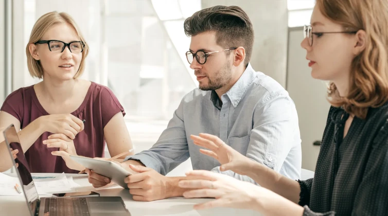 Two women and a man talking to each other