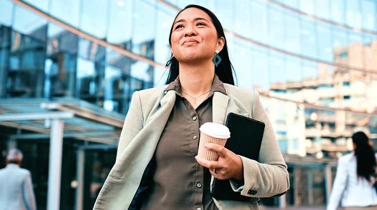 A woman smiling holding a cup of coffee