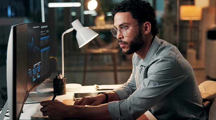 Man taking notes and looking at computer
