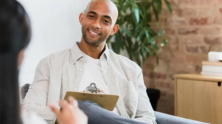 Man sitting down talking to a woman