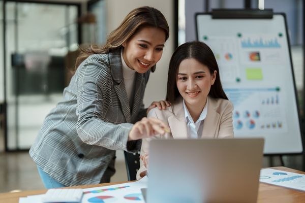 data analysts looking at data on laptop