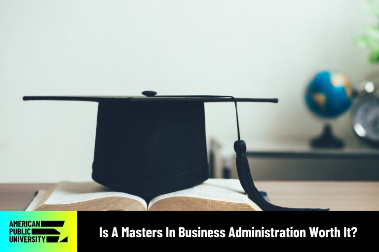 is-a-masters-in-business-administration-worth-it masters in business administration text book with graduation cap